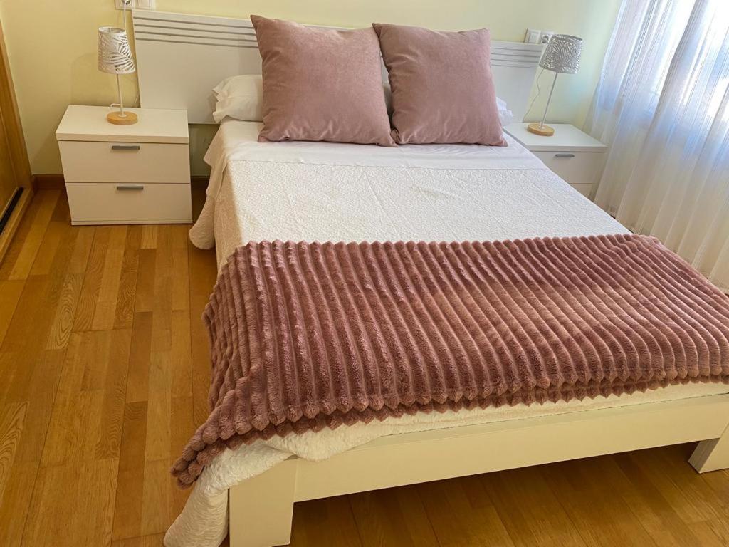 a bedroom with a bed with two night stands and two lamps at Santiaguiño in Padrón