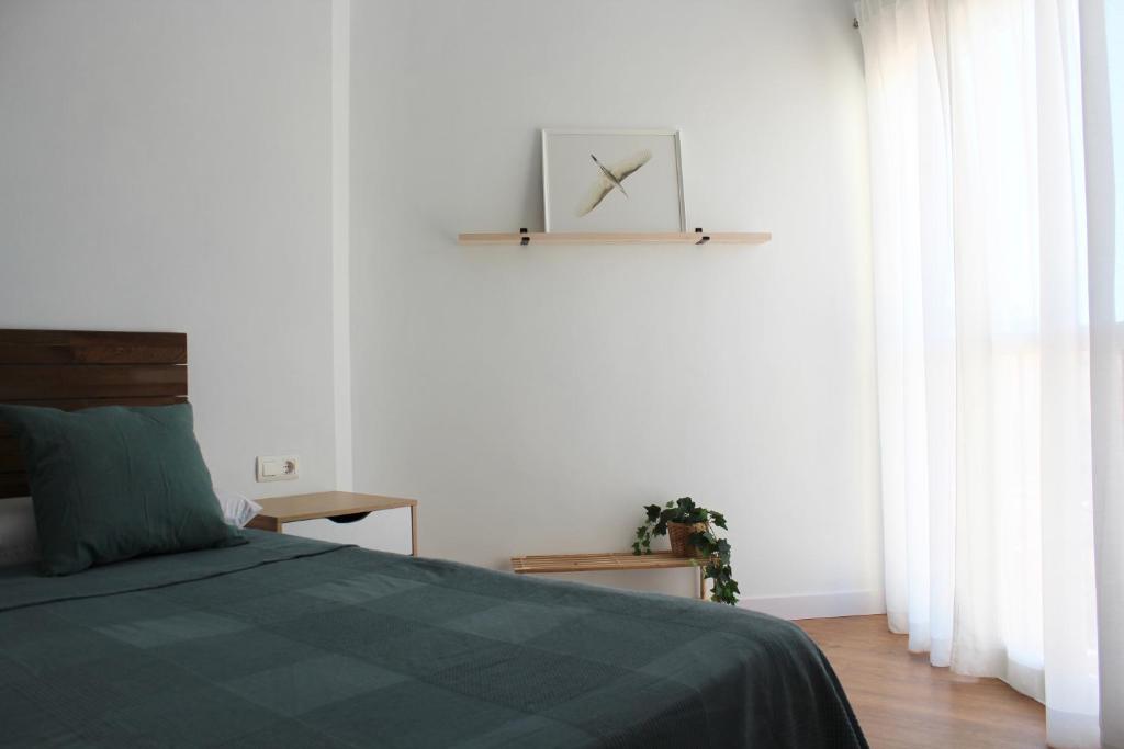sypialnia z łóżkiem i zegarem na ścianie w obiekcie Beautiful brand new 2 bedroom flat with terrace w Maladze