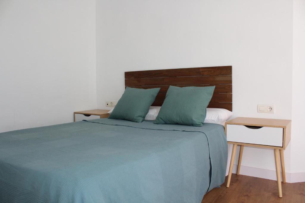 sypialnia z łóżkiem z niebieską pościelą i biurkiem w obiekcie Beautiful brand new 2 bedroom flat with terrace w Maladze