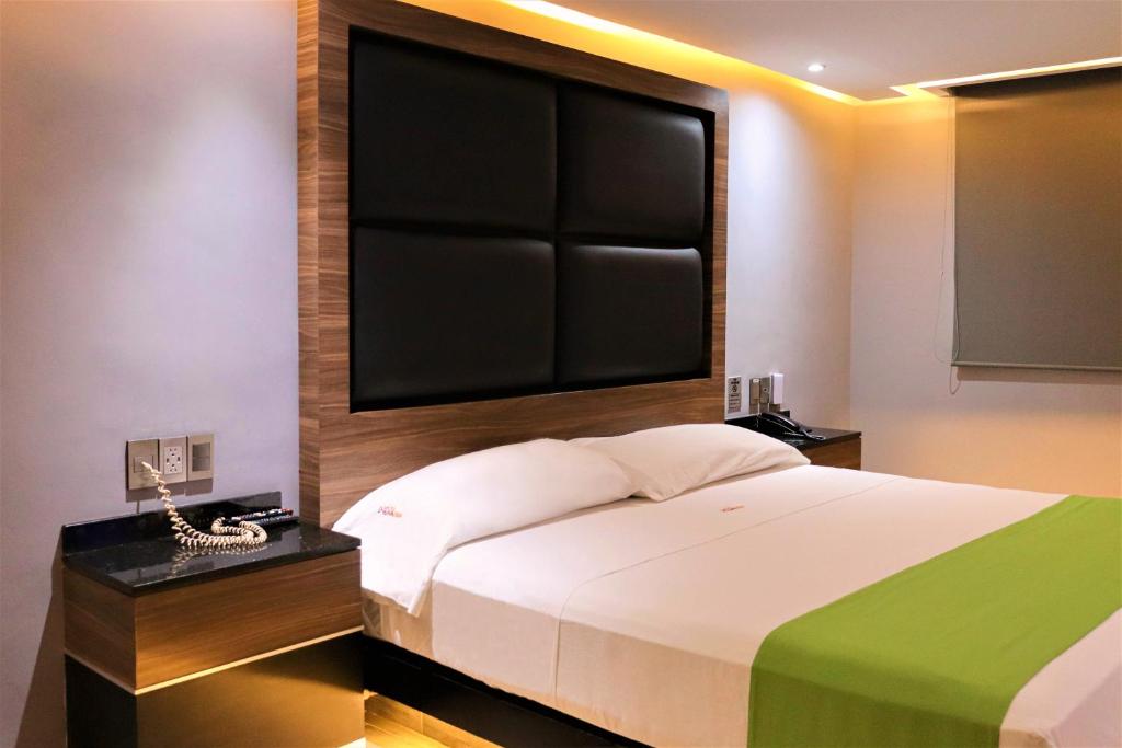 1 dormitorio con 1 cama con una pantalla grande encima en Auto-Hotel Playa Linda en Veracruz