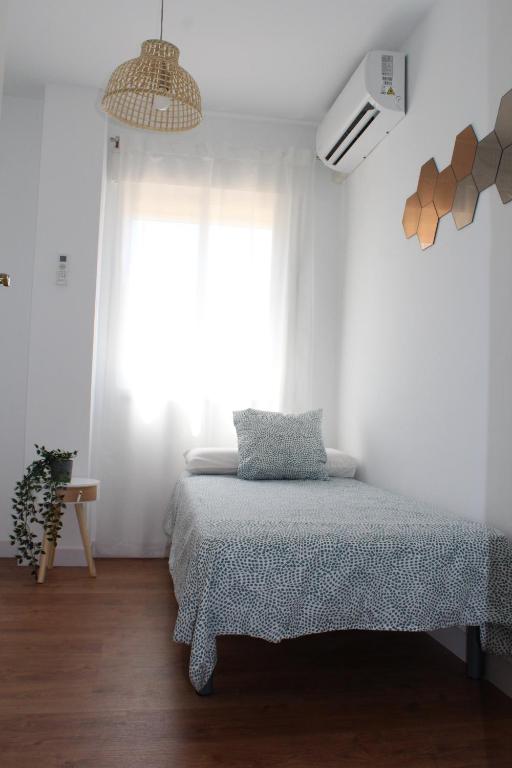 sypialnia z łóżkiem i dużym oknem w obiekcie Beautiful brand new 2 bedroom flat with terrace w Maladze