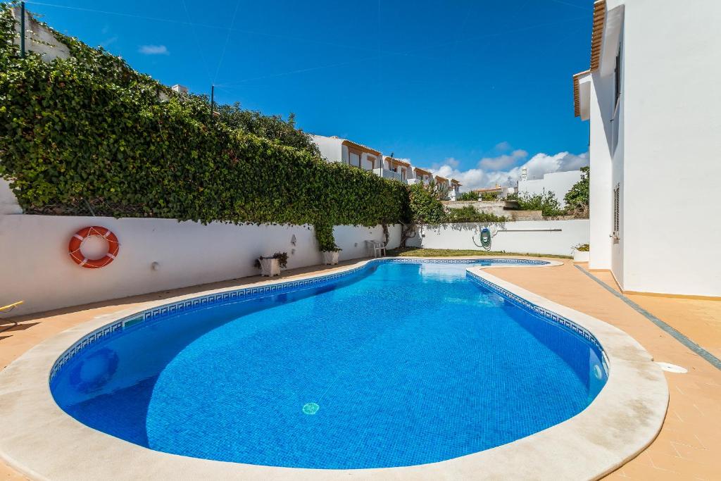 a large blue swimming pool next to a building at Appartement ALGARDEN Olhos d'Agua in Olhos de Água