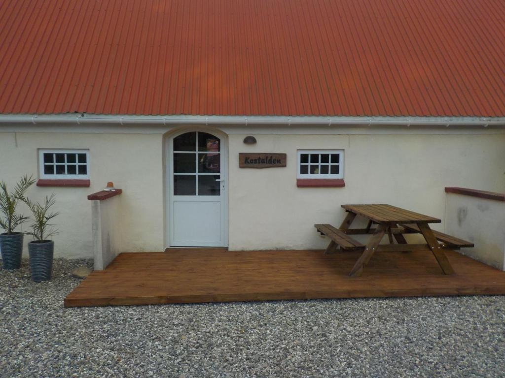 賽比的住宿－Lyngsågaard K，白色建筑前的野餐桌,红色屋顶