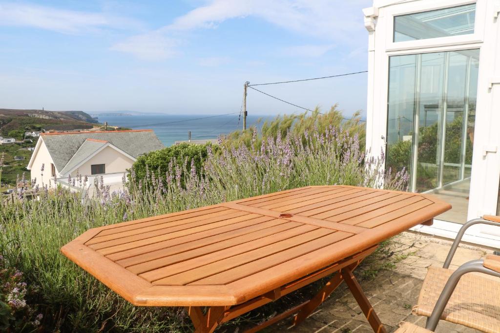 a wooden table sitting on the side of a house at Hillcrest in Truro