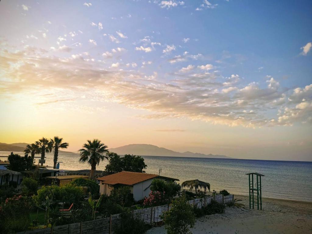Blick auf einen Strand mit Palmen und das Meer in der Unterkunft Anatolikos Rooms in Alykes