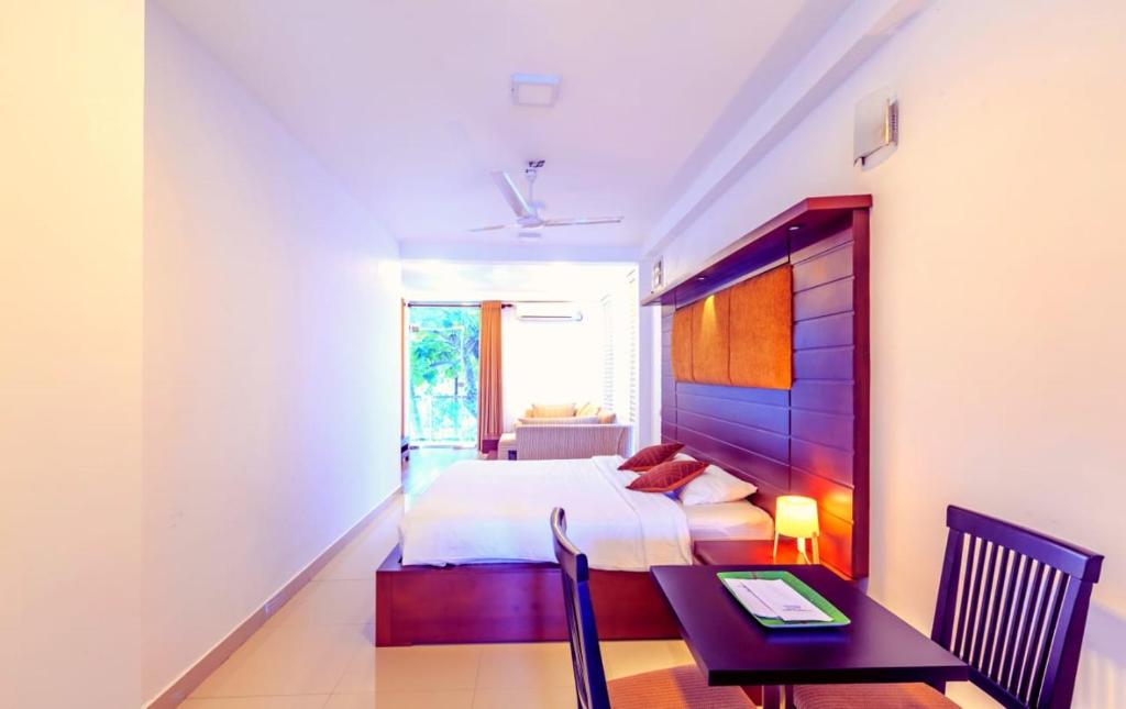 um quarto com uma cama, uma mesa e uma secretária em Oak Residencies em Kiribathgoda