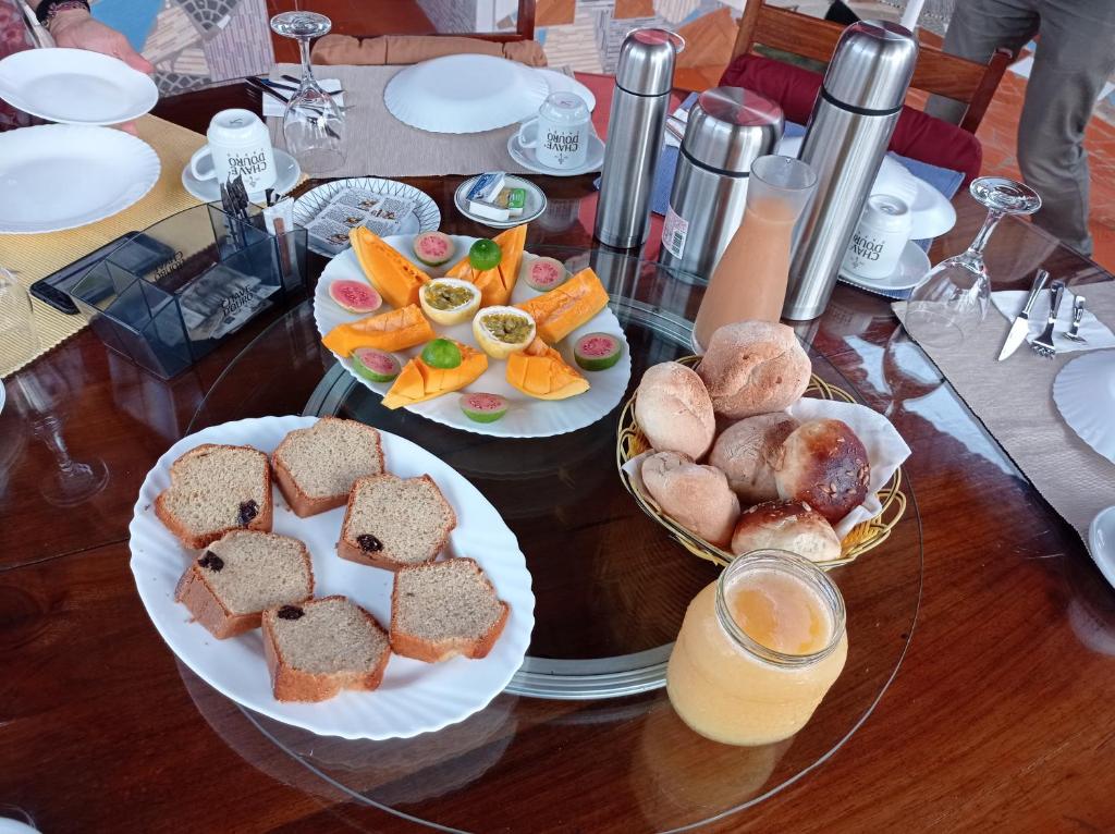 a wooden table with two plates of food on it at Residencial Brigada in Santo António