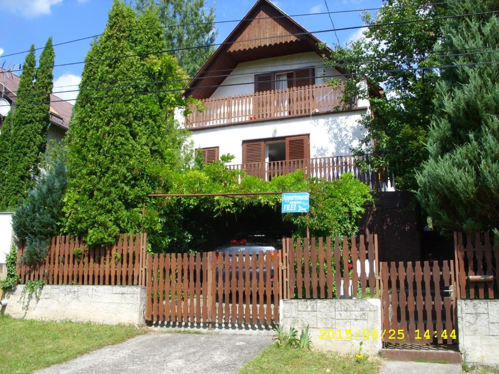 una valla de madera frente a una casa en Orgona apartman, en Igal