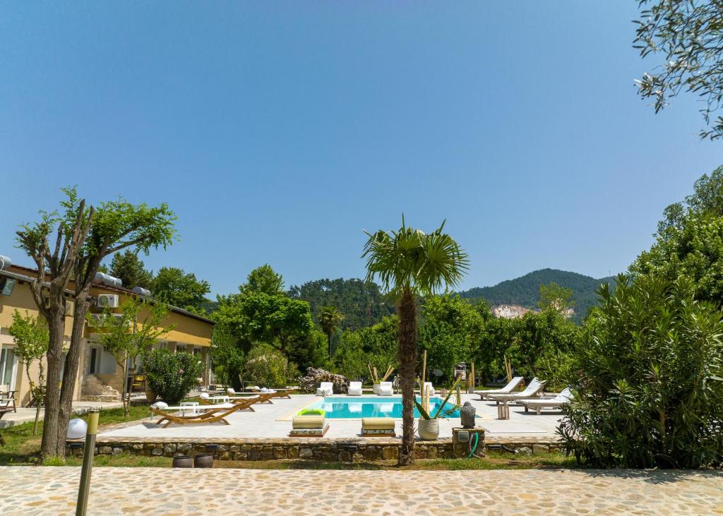 un complexe avec une piscine et des palmiers dans l'établissement Natura Bungalows, à Thasos