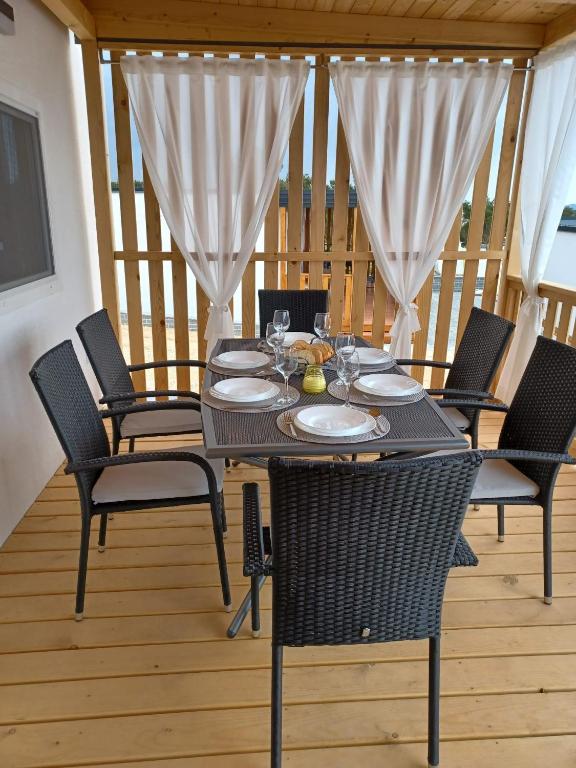a black table and chairs on a deck at CHARTA Mobile Home Meon in Drage