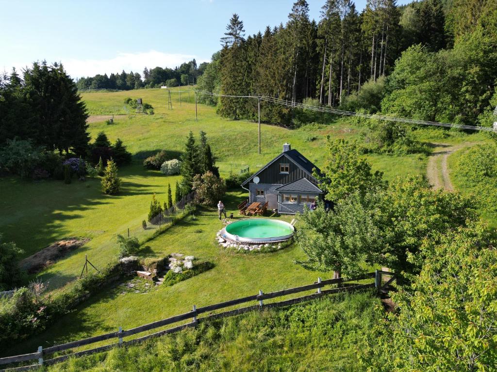 ein Haus auf einem Hügel mit Pool im Hof in der Unterkunft Ferienhäuschen Blessberg in Schalkau