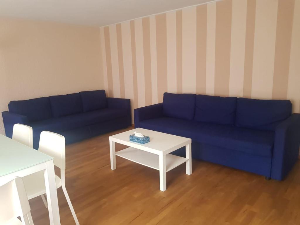 - un salon avec un canapé bleu et une table dans l'établissement 2 Rooms cosy Apartment near Liechtenstein, à Haag