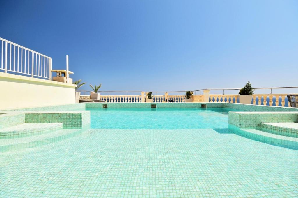 a swimming pool with blue tiles on the ground at Atico Suite Ola Blanca in Cala de Finestrat