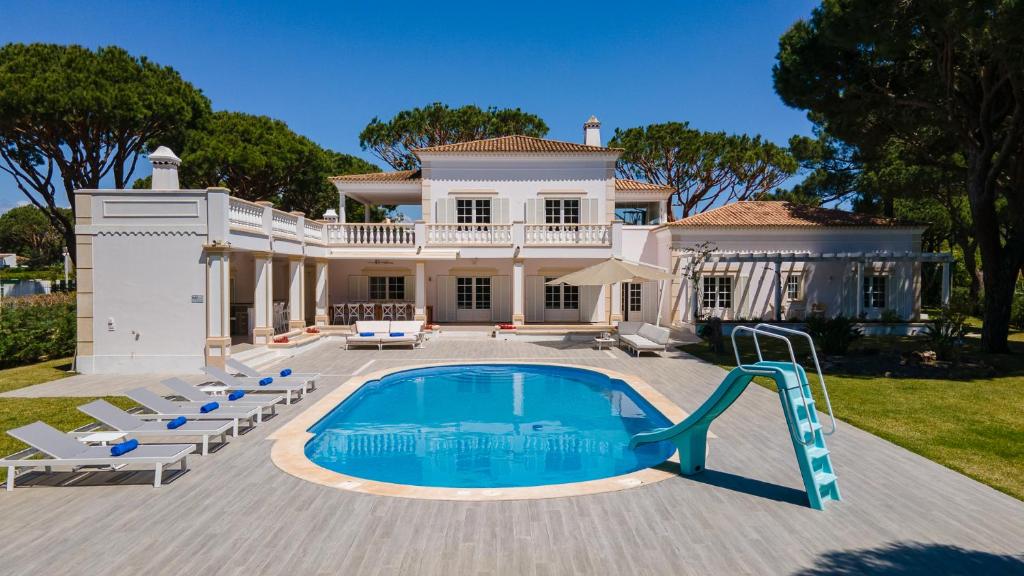 une grande maison avec une piscine dans la cour dans l'établissement Portuguese mansion close to marina, golf and beach., à Vilamoura