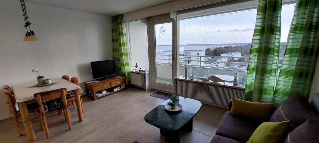 uma sala de estar com vista para uma varanda em MEERBLICK PERLE, 3-RAUM-FEWO AM HANSAPARK em Sierksdorf