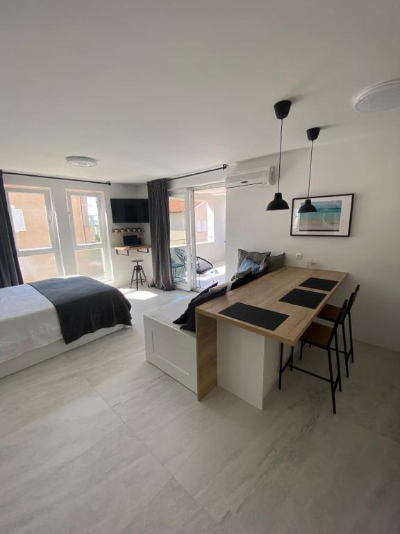 a bedroom with a bed and a desk in it at Diva Sunset Apartment in Novalja