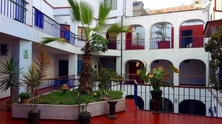 un bâtiment avec une cour plantée de palmiers et de plantes dans l'établissement Central, cozy & self-contained petfriendly apartments in the heart of Miraflores, à Lima