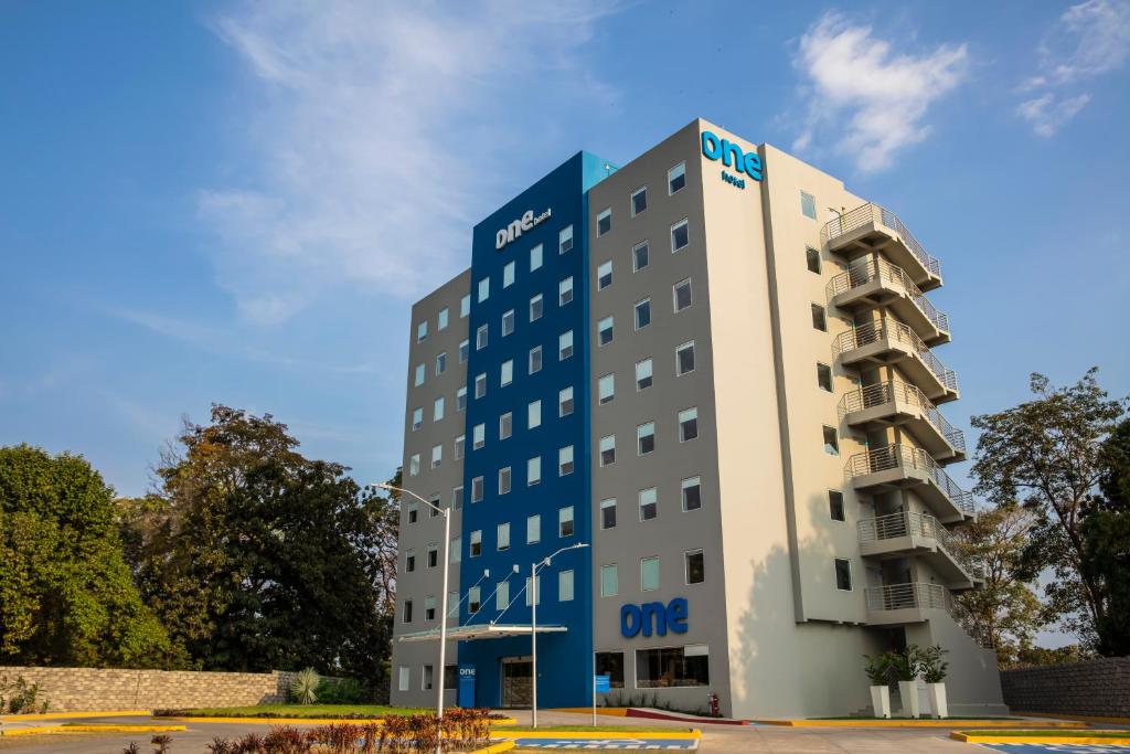 um hotel com um edifício azul e branco em One Tapachula em Tapachula