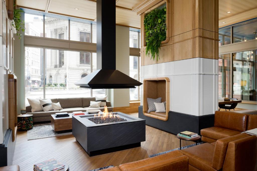 a living room with a fireplace and a couch at Kimpton Schofield Hotel by IHG in Cleveland