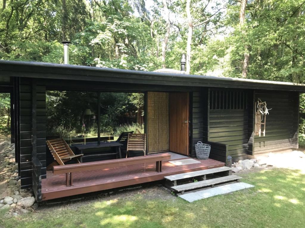 a small cabin with a porch and a patio at Fins Boshuis in Meppen