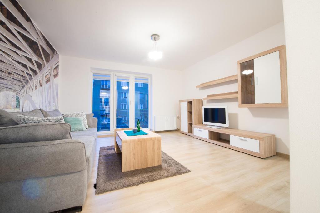 een woonkamer met een bank en een tv bij Apartman RÁZUSA CENTRUM in Banská Bystrica