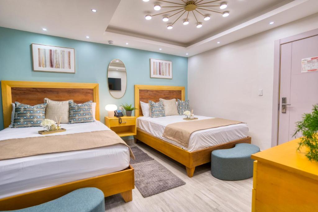 2 Betten in einem Zimmer mit blauen Wänden in der Unterkunft Melina Hotel in Higuey