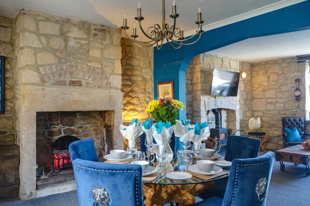 a dining room with a table and chairs and a fireplace at The Anchorage - sea views and beach on doorstep in Amble