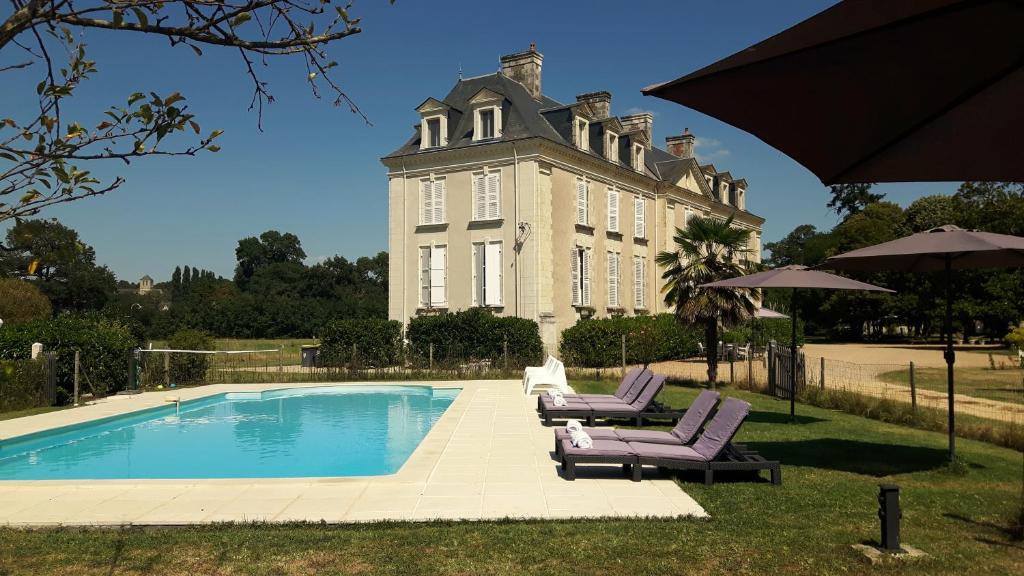 a large building with a swimming pool in front of it at Château La Mothaye in Brion