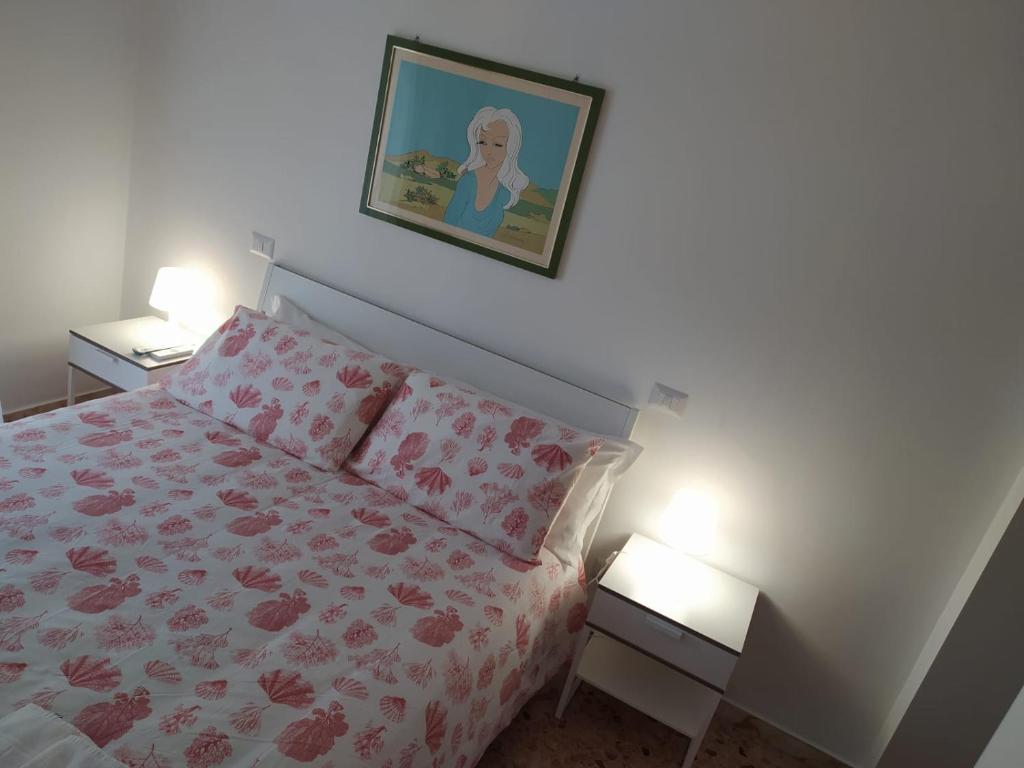 een slaapkamer met een bed en een foto aan de muur bij Apartments for you in Matera