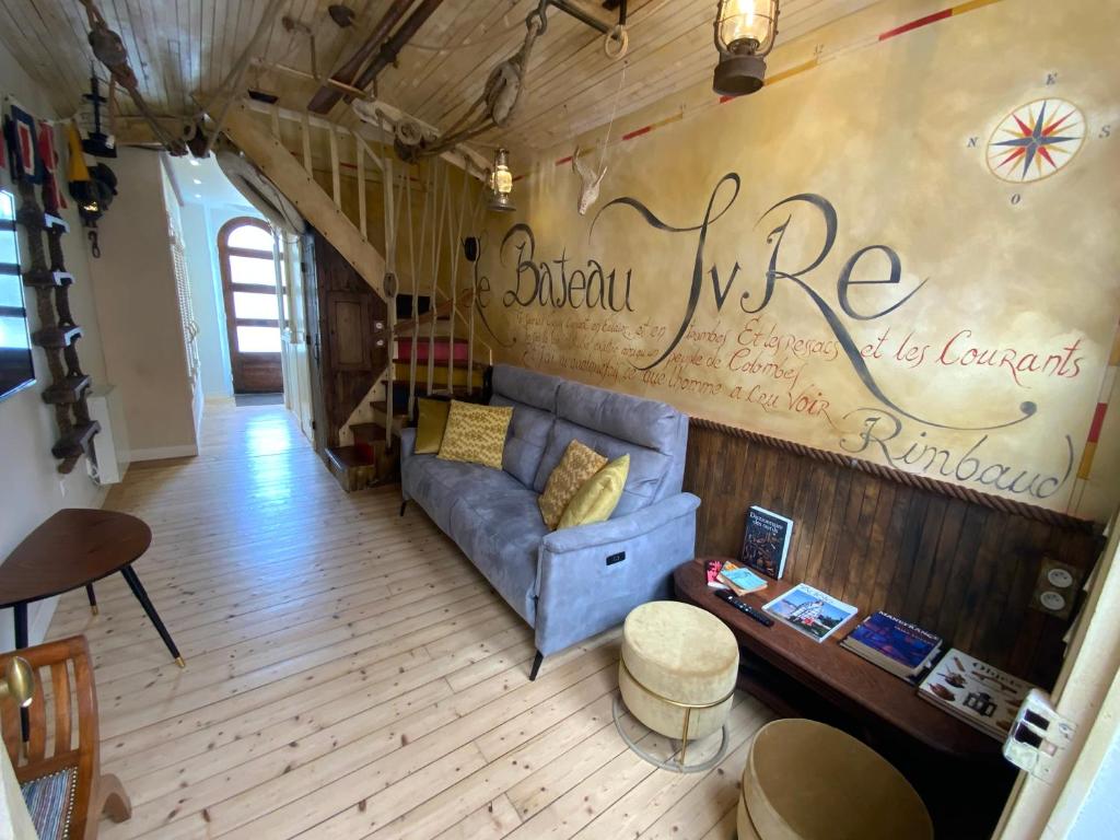 - un salon doté d'un canapé bleu avec un mur d'écriture dans l'établissement Maison bord de mer « Le Bateau IvRe », à Saint-Malo