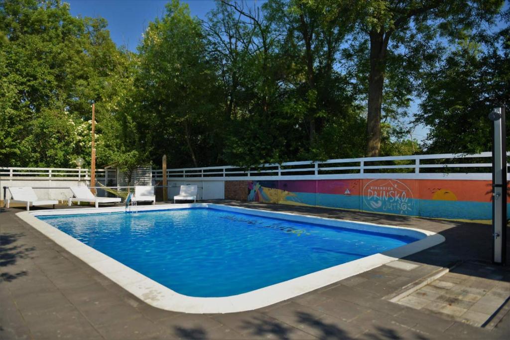 a swimming pool with blue water in a yard at Drinsko jutro in Bijeljina