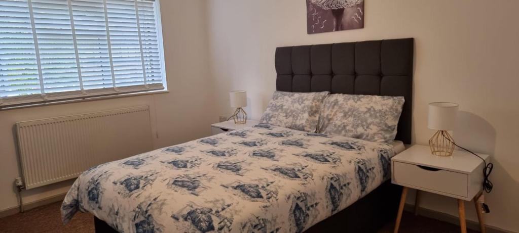 Schlafzimmer mit einem Bett mit einer blauen und weißen Bettdecke in der Unterkunft 3 bed bedroom house with garden in Thamesmead