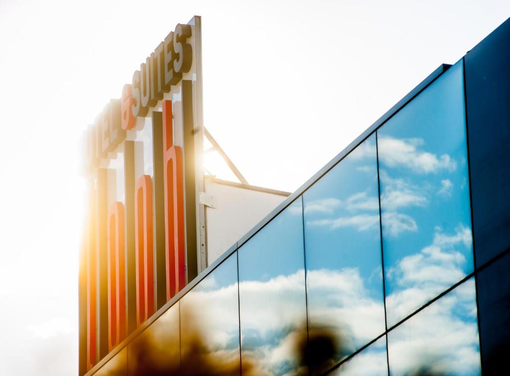 a building with the reflection of the sky in the windows at Hotel Loob Madrid in Torrejón de Ardoz