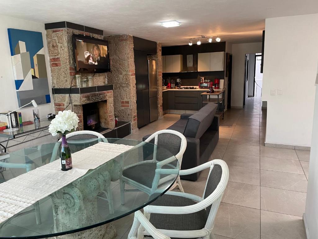 une salle à manger et une cuisine avec une table et des chaises en verre dans l'établissement Alojamiento completo, con una excelente ubicación, à Guadalajara
