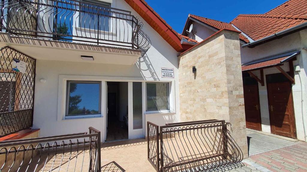 a house with a balcony and a wrought iron fence at Apartment Zamardi 3 in Zamárdi