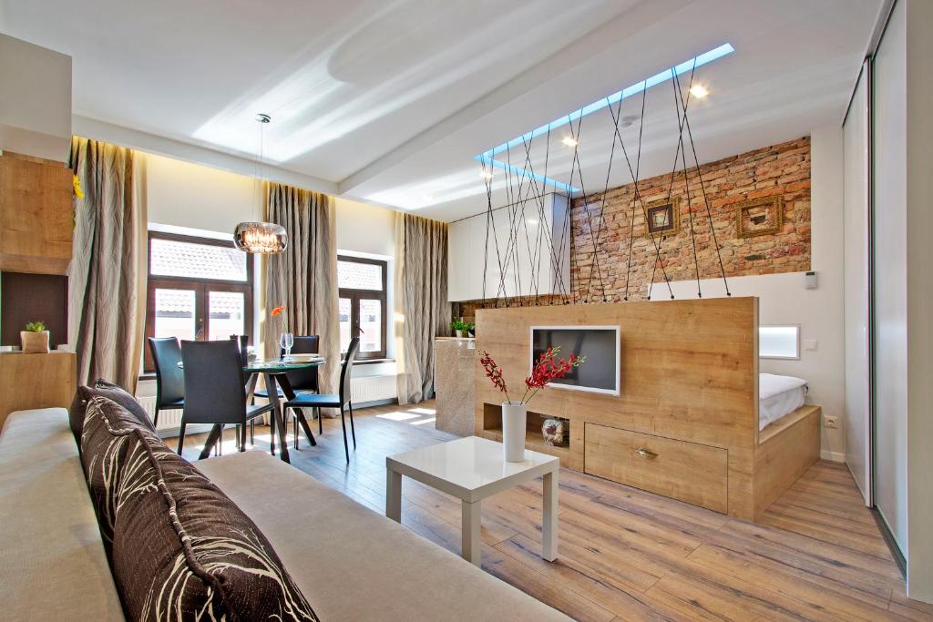 a living room with a couch and a dining room at Angel Wing Apartamentai in Vilnius