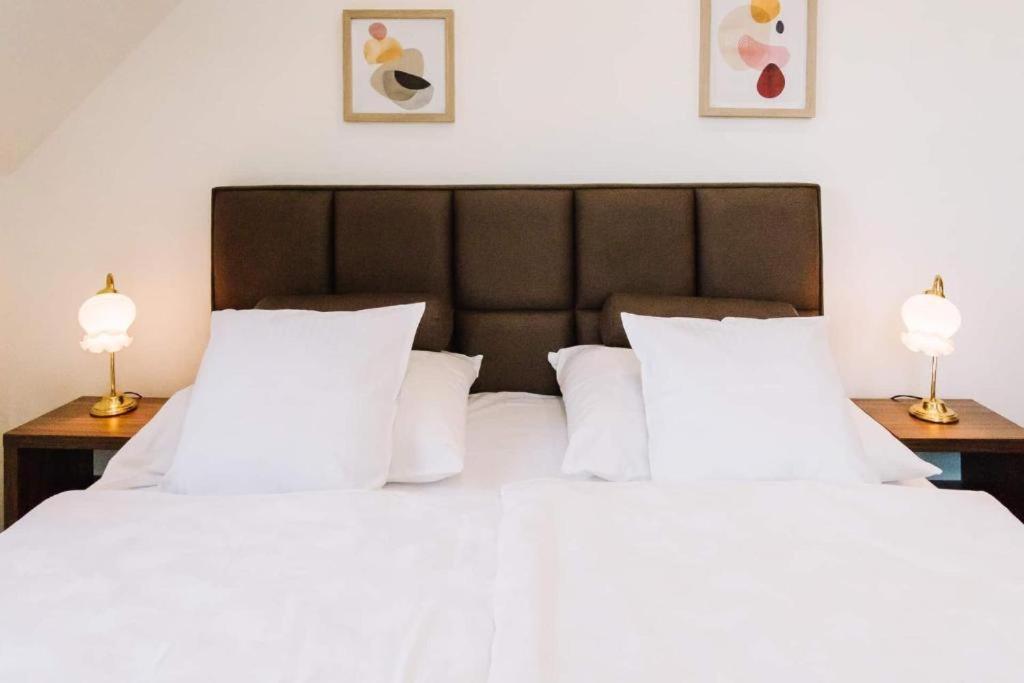 sypialnia z 2 łóżkami z białymi poduszkami i 2 lampami w obiekcie Diófa Apartman w mieście Keszthely