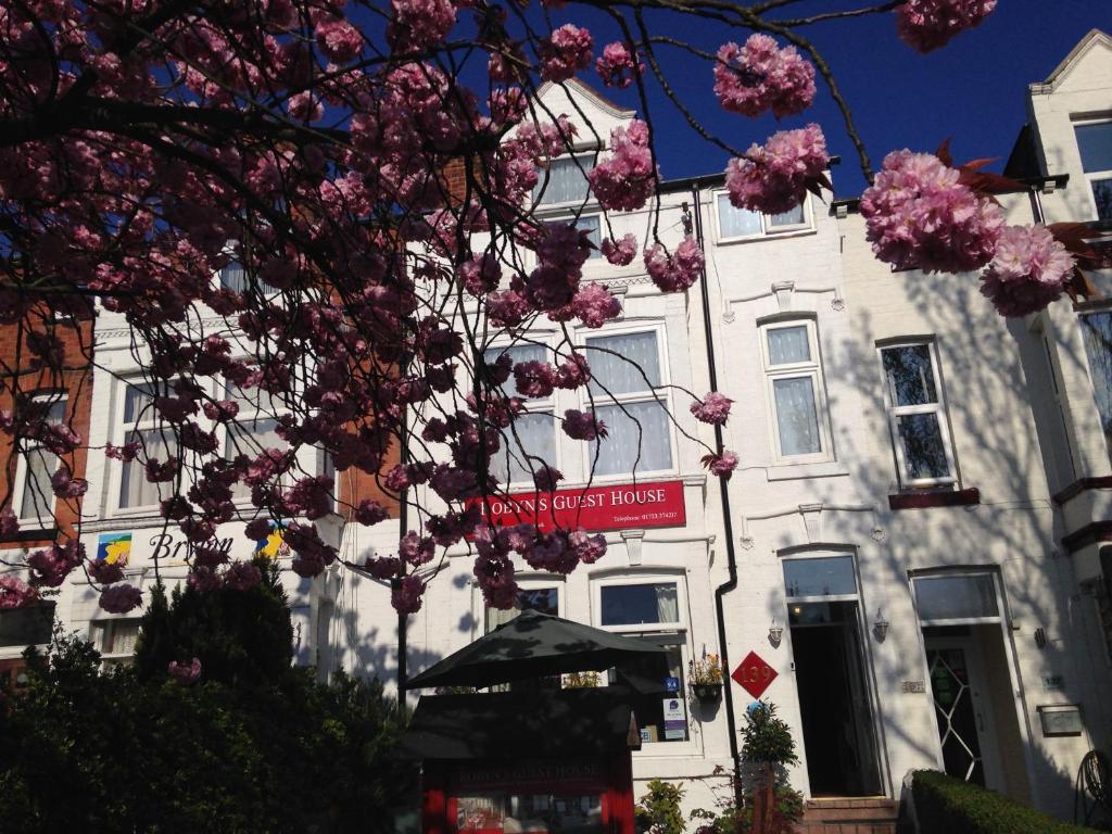 a street sign in front of a building with pink flowers at Robyn's Guest House in Scarborough