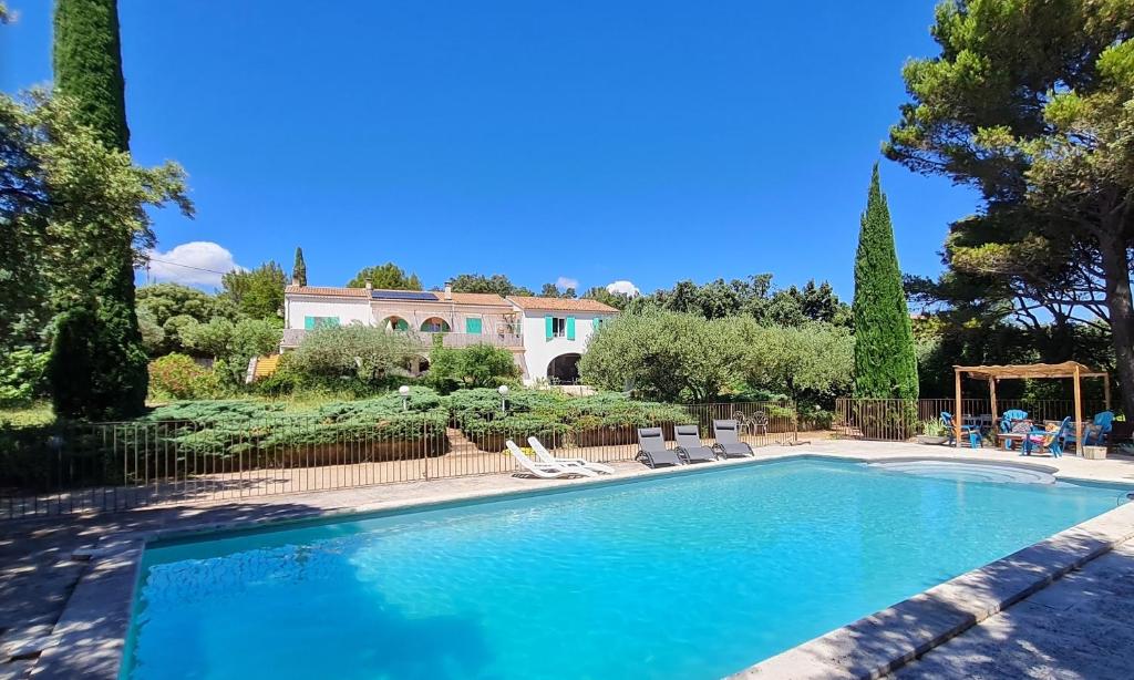 a swimming pool in front of a house at Domaine Colibri en Provence in Pujaut