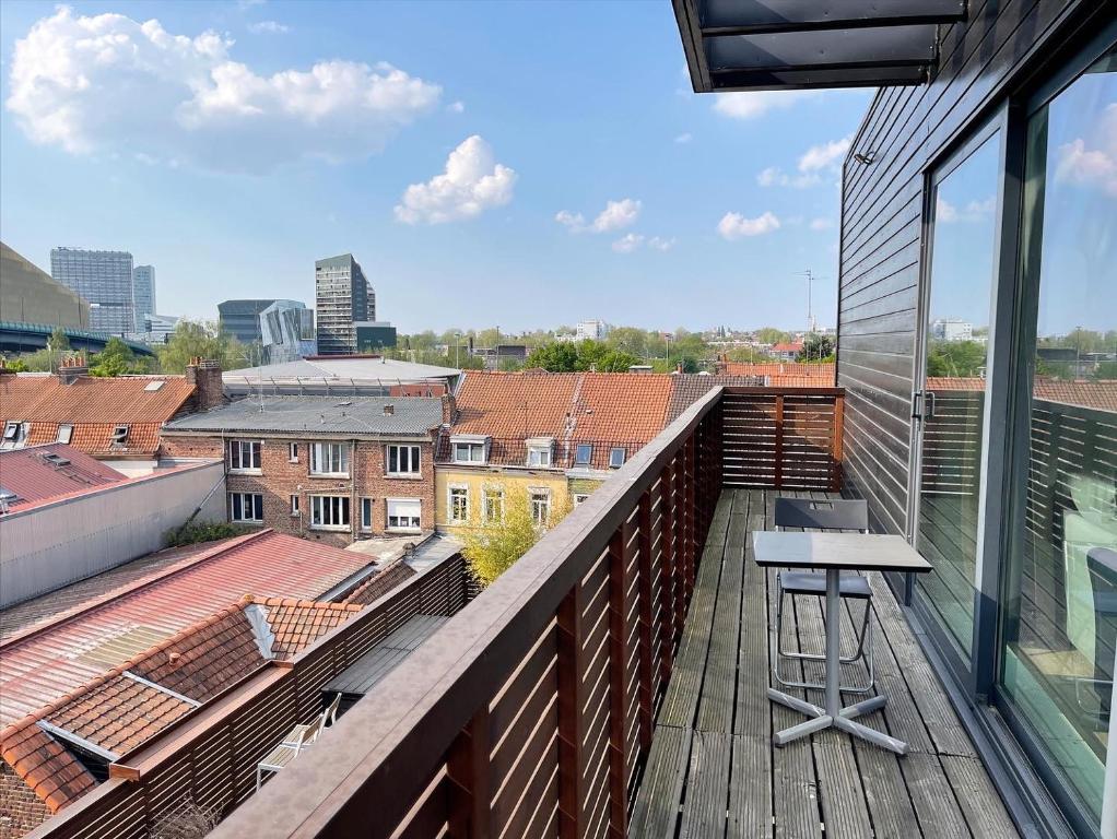 a balcony with a table and a view of the city at The ROOF - LILLE GRAND PALAIS in Lille