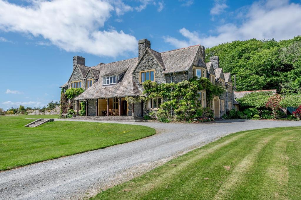 a large house with a gravel driveway at Plas Gwynfryn in Llanbedr