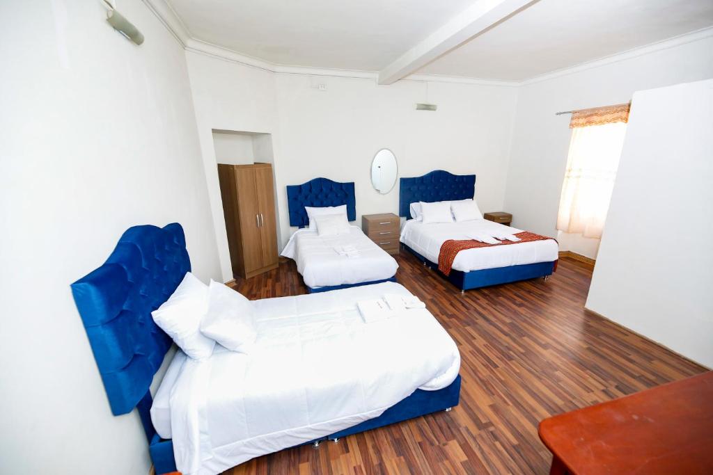 a hotel room with two beds and a table at PARDOS HOUSE INN in Cusco