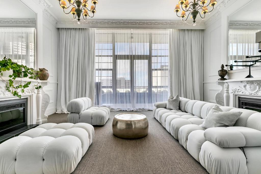 een witte woonkamer met witte meubels en een kroonluchter bij QV Luxury Elegant 2 Bedroom with Wifi & Parking -1035 in Auckland
