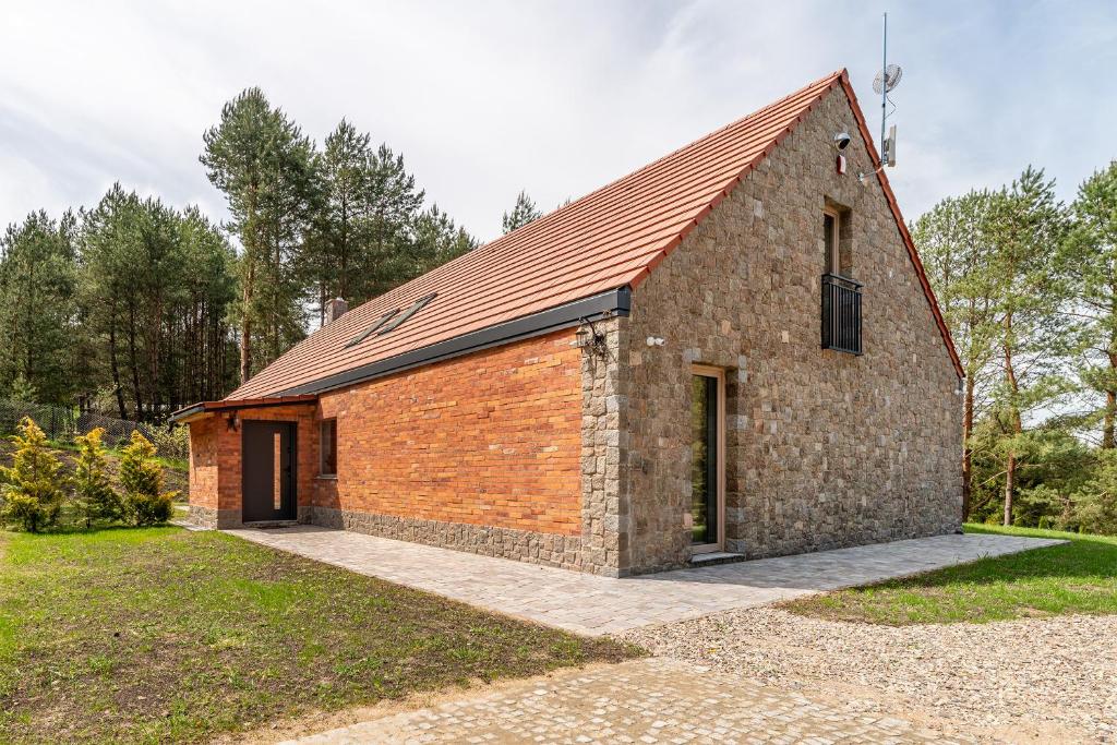 a brick building with a red roof at Villa Warminska in Kręsk