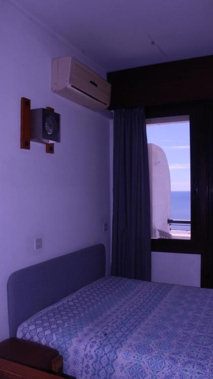 1 dormitorio con cama y ventana en Monte Gordo Beach Sky Flat en Monte Gordo