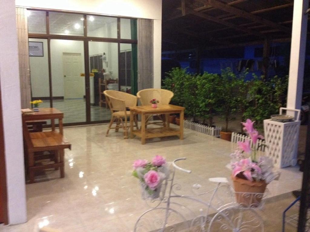 um quarto com cadeiras e uma mesa e algumas flores em Space Ben Guest House @ Muangkao em Sukhothai