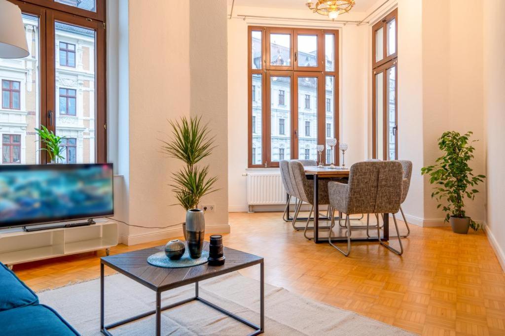 a living room with a couch and a tv and a table at Stilvolle FeWo Augusta I in Görlitz