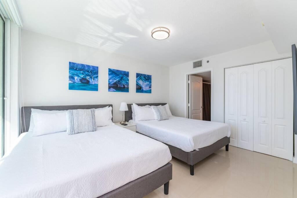 マイアミにあるStunning 2BR with Ocean View at Brickell, Free Parkingの白い壁のベッドルーム1室(ベッド2台付)