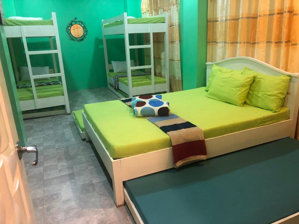 Airusxander Front Beach Resort في كاراموان: غرفة نوم مع سرير وسريرين بطابقين