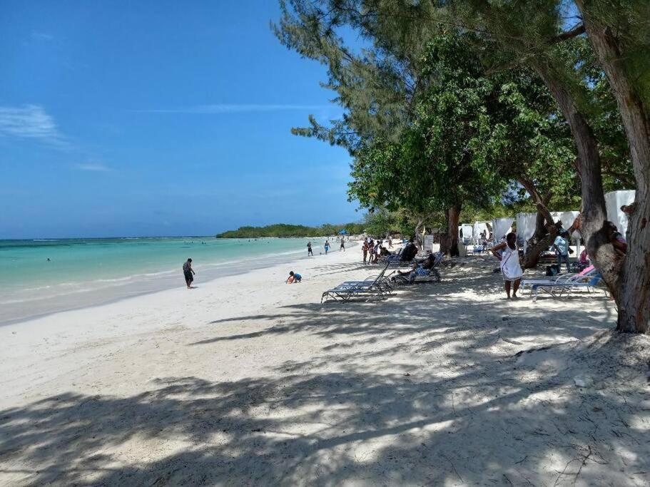 a group of people on a beach near the water at Villa verde Jamaica - Oceanview Getaway, Gated & Secured in Falmouth